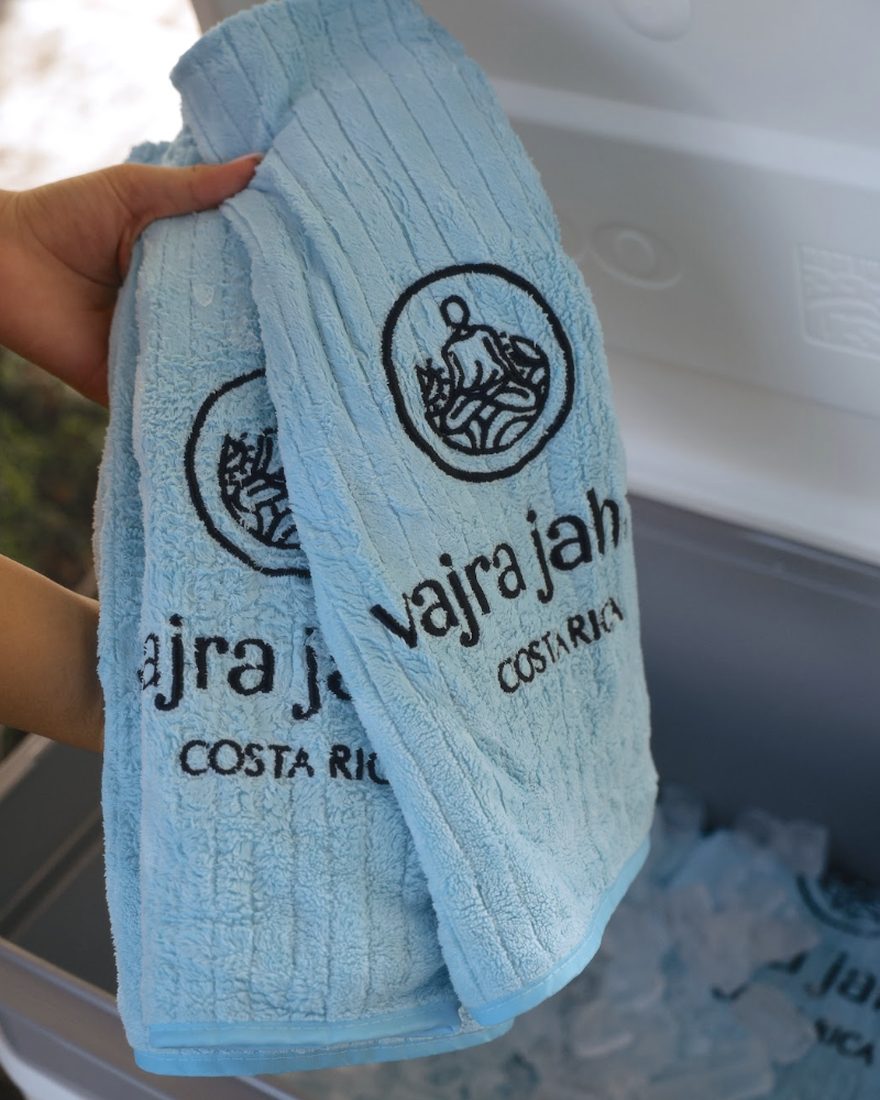 A Vajra Jahra cold towel being lifted out of a cooler packed with ice.