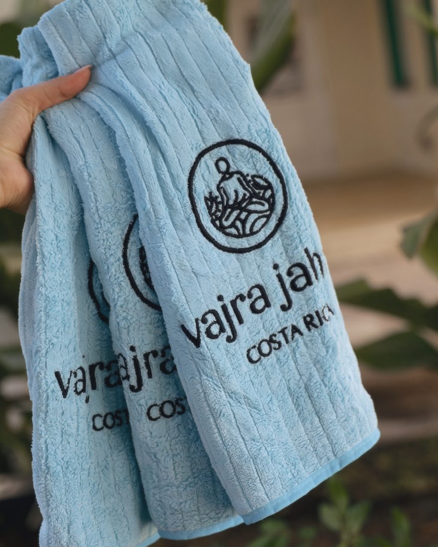 A folded stack of pale blue Vajra Jahra Costa Rica towels held up in the sun.